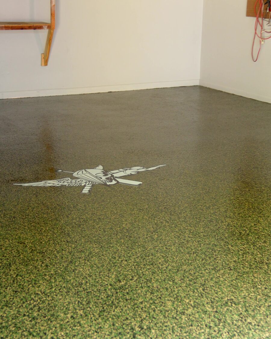 Finished chip flake garage floor with two custom stencil inlays, seen wall to wall