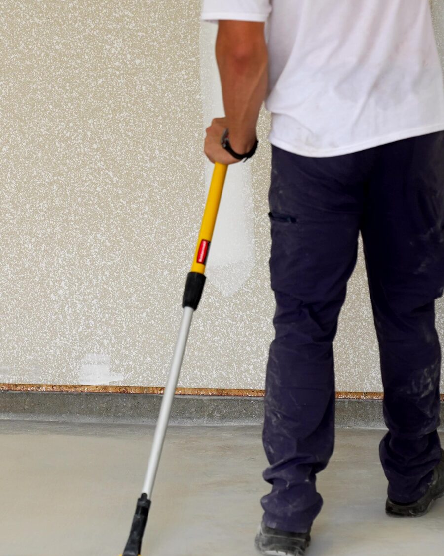 Working a fresh coat out to the wall with a squeegee